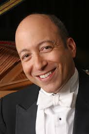 a man in a tux with a piano in background